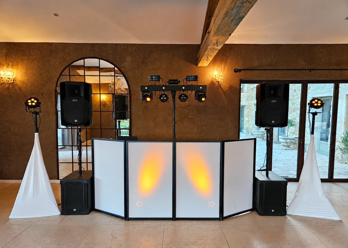 Installation de Nico dans une salle de réception : cabine DJ, enceintes, caissons de basses et jeux de lumières